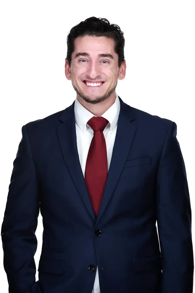 Nick Yeros professional headshot in navy suit against white background.