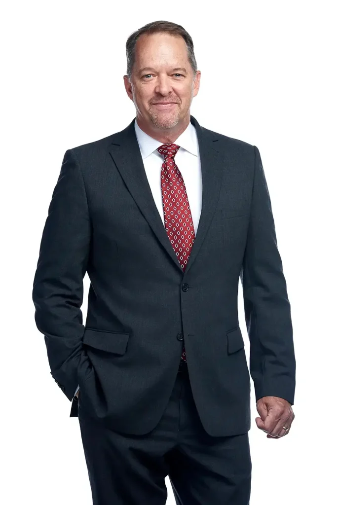 Professional businessman in navy suit posing for corporate headshot portrait.